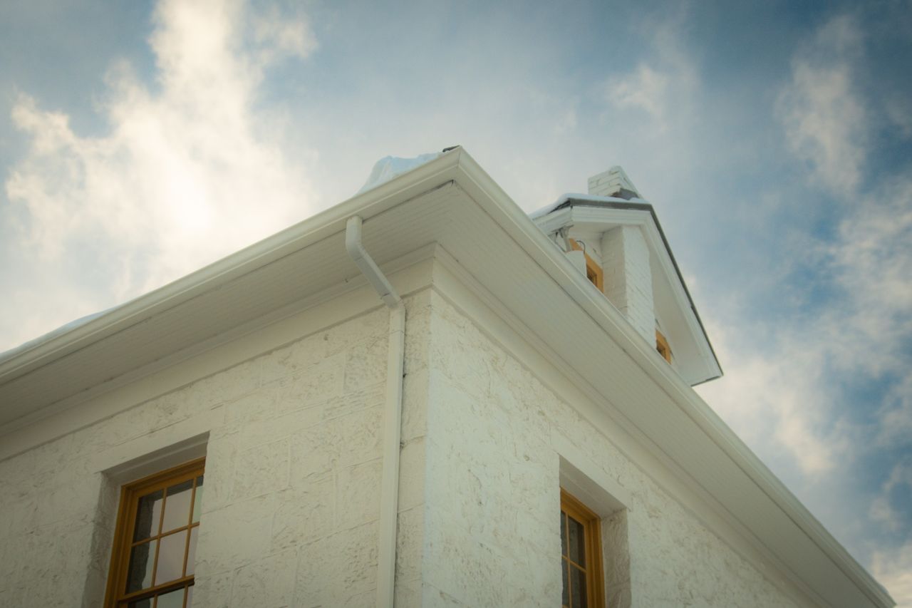 Mastering the First Impression: Your intriguing post title goes here A vintage house with an elegant gable roof viewed from below against a partially cloudy sky.